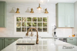 Kitchen Sink and Window with Brass Fixtures and Green Cabinets | Ground Up Builders