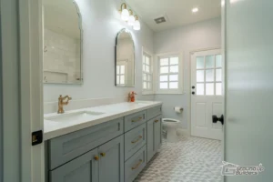 Soft Blue Vanity Bathroom with Gold Fixtures and Dual Mirrors | Ground Up Builders