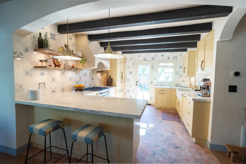 Modern kitchen with light wood cabinets and a marble island.