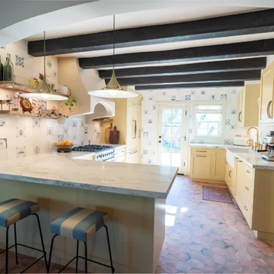 Modern kitchen with light wood cabinets and a marble island.