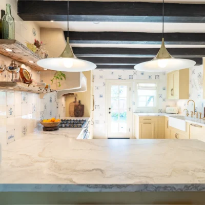 Modern kitchen with light wood cabinets and a marble island.