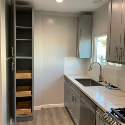 Modern kitchen with gray cabinetry- Ground Up Builders